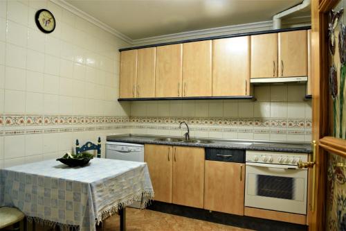 - une cuisine avec des placards en bois et une table avec un évier dans l'établissement Casa Rural El Camino, à Montemayor de Pililla