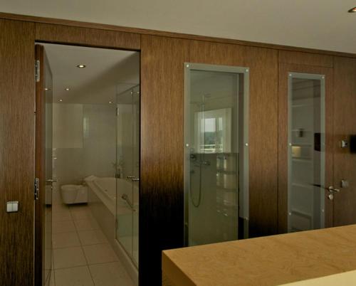 a bathroom with a walk in shower and a glass door at Vitalia Seehotel in Bad Segeberg