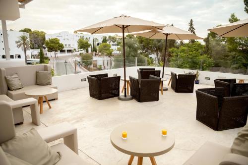 a patio with chairs and tables and an umbrella at Sentido Fido Tucan - Adults Only in Cala d´Or