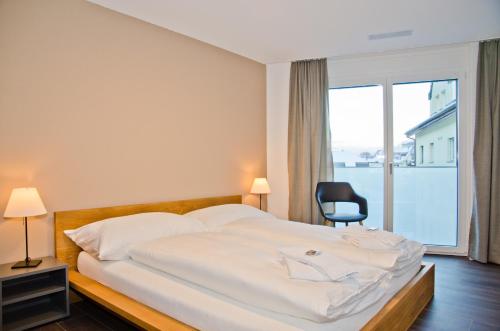 una camera con un letto, una sedia e una finestra di Apartment Edelwyss - GriwaRent AG a Interlaken