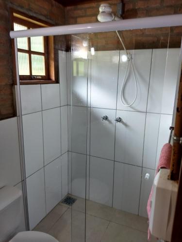 a shower with glass doors in a bathroom at Casa do Bosque in Visconde De Maua