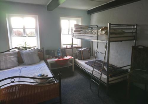 1 Schlafzimmer mit 2 Etagenbetten und einem Schreibtisch in der Unterkunft Ferienzimmervermietung Reitferien in Skærbæk