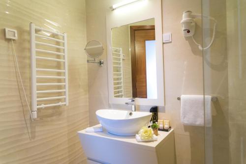 a bathroom with a sink and a shower with a mirror at Hotel Kadmo by Aycon in Budva