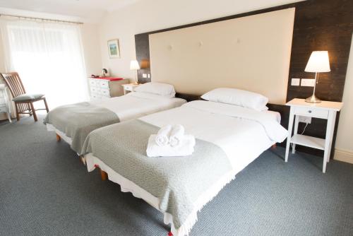 a hotel room with two beds with towels on them at Connemara Lake Hotel in Oughterard