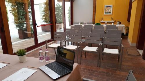 a laptop sitting on a table in a room with chairs at UNAHOTELS Eco Hotel Villa Costanza Venezia in Mestre