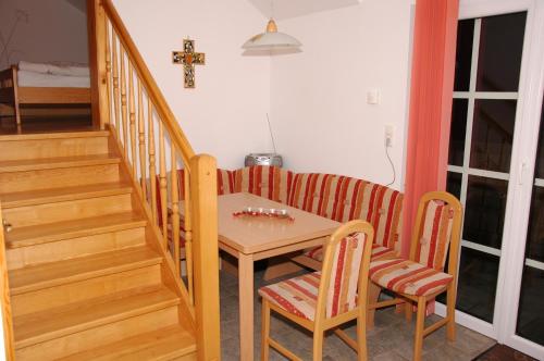 a small table and chairs in a room with stairs at Biohof Ebenbauer in Waidhofen an der Ybbs