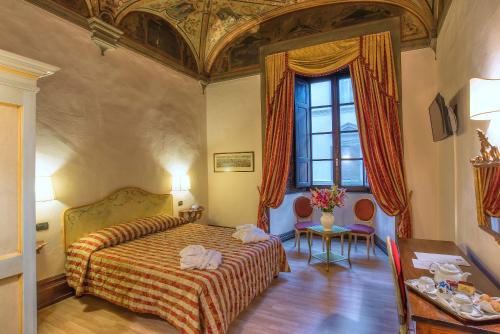 a hotel room with a bed and a window at Hotel Paris in Florence
