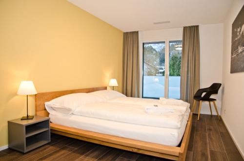 une chambre d'hôtel avec un lit et une fenêtre dans l'établissement Apartment Gänseblüemli - GriwaRent AG, à Interlaken