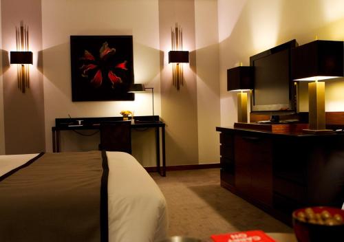 a hotel room with a bed and a flat screen tv at Hotel Dighton in Oliveira de Azemeis