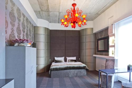 a bedroom with a bed and a red chandelier at G Design Hotel in Ljubljana