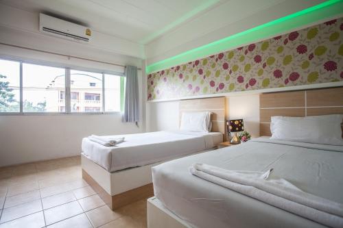 a hotel room with two beds and a window at The Greenery Hotel in Krabi