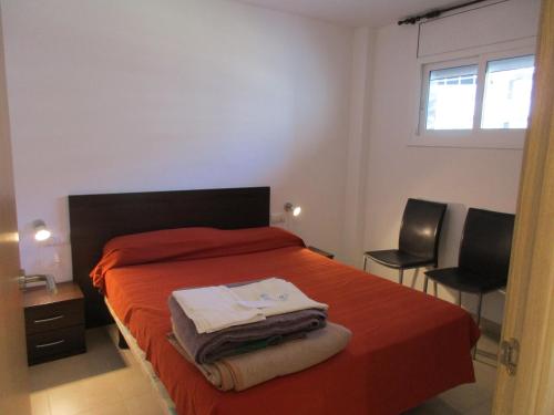 a bedroom with a bed with two chairs and a window at Rocamaura IV-2-10 inmoestartit in L'Estartit