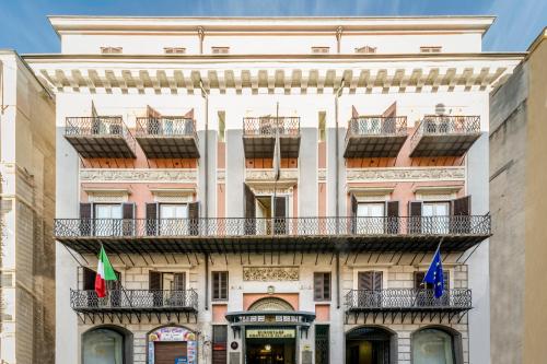 a building with balconies and flags on it at Eurostars Centrale Palace Hotel in Palermo