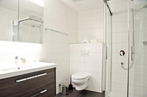 e bagno con servizi igienici, lavandino e doccia. di Apartment Flüehblüemli - GriwaRent AG a Interlaken