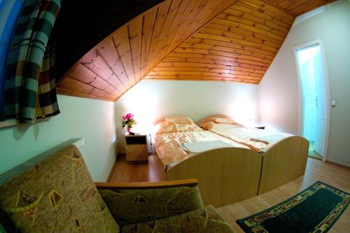 una camera con letto e soffitto in legno di Gilde étterem és panzió a Pilisvörösvár