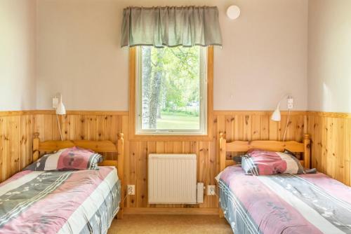 2 camas en una habitación con ventana en First Camp Hökensås-Tidaholm, en Tidaholm