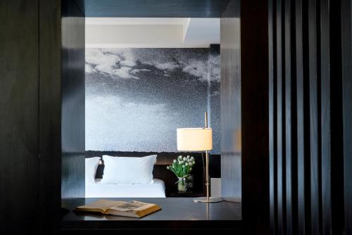 a bedroom with a bed and a table with a lamp at Aire Hotel & Ancient Baths in Almería