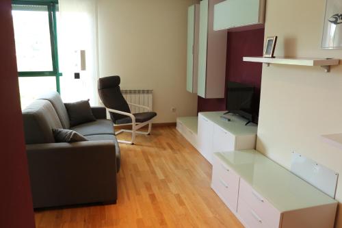 uma sala de estar com um sofá e uma televisão em adrimarcangas em Cangas de Onís