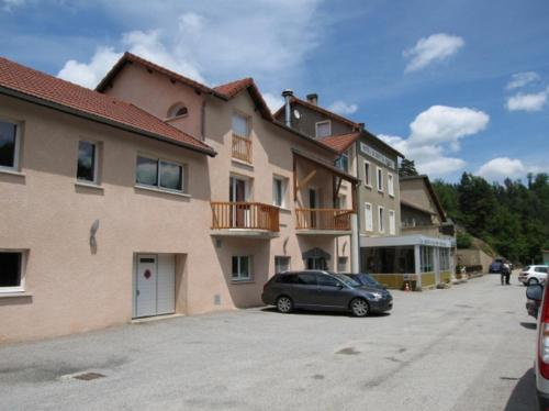 a car parked in a parking lot next to a building at Hôtel du Bout du Monde in Saint-Flour