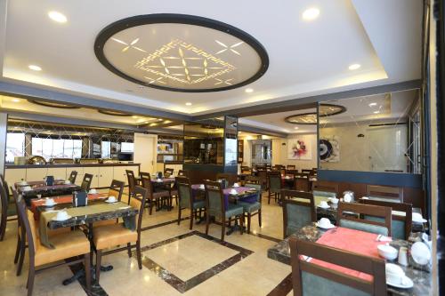 a restaurant with tables and chairs and a large clock on the ceiling at Life Corner Hotel in Izmir