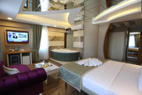 a bedroom with a bed and a tub and a tv at Life Corner Hotel in Izmir
