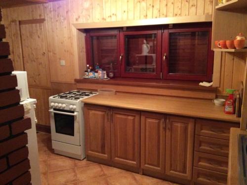 a kitchen with wooden cabinets and a stove at Chata Kiki Malino Brdo in Ružomberok