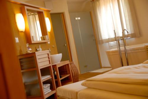 a bedroom with a bed and a bathroom with a mirror at Weingut Tauss in Leutschach