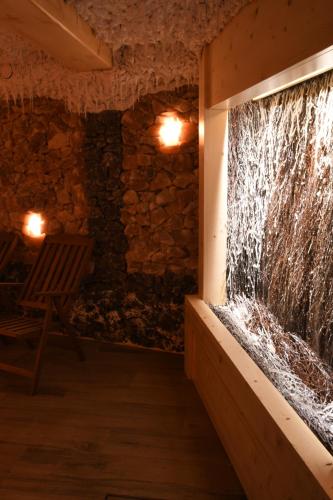 a stone walled aquarium in a room with a chair at Pensjonat Sekuła*** in Bukowina Tatrzańska