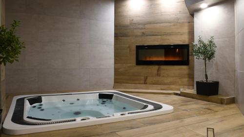 a jacuzzi tub in a room with a fireplace at Pensjonat Sekuła*** in Bukowina Tatrzańska