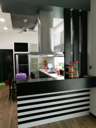 a kitchen with a black and white counter top at Barakah Homestay in Alor Setar