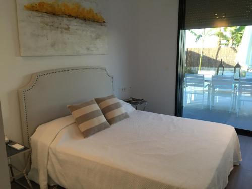 um quarto com uma cama branca e 2 almofadas em Casa de lujo frente a la playa de Es Trenc em Sa Ràpita