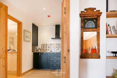 a kitchen with blue cabinets and a mirror at Alfama Unique & Romantic Studio by LovelyStay in Lisbon