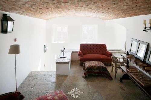 a living room with a red couch and a table at Alfama Unique & Romantic Studio by LovelyStay in Lisbon