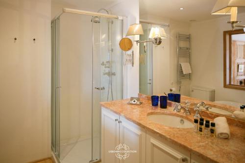 a bathroom with a glass shower and a sink at Alfama Unique & Romantic Studio by LovelyStay in Lisbon