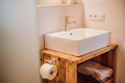 a bathroom with a white sink and a toilet paper roll at Biochalet-Ebenbauer in Schladming