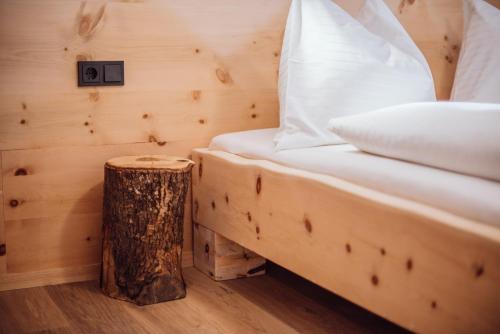 a bed in a wooden room with a tree stump next to it at Biochalet-Ebenbauer in Schladming