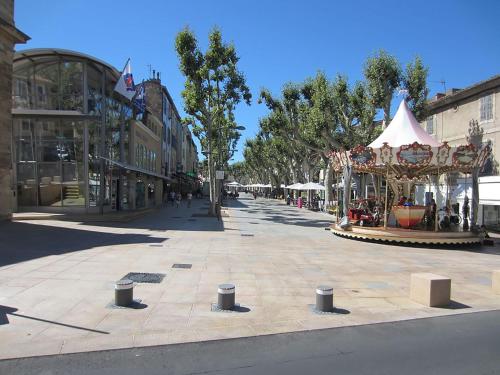 a street with a carousel in the middle of a city at Un Petit Coin de Provence - Istres - Maison Contemporaine Avec Piscine Privée Chauffée, Entre Plages Et Provence, Borne 11 kW in Istres
