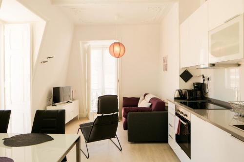 eine Küche und ein Wohnzimmer mit einem Tisch und Stühlen in der Unterkunft Classic and Comfortable Topfloor Apartment 13 by Lisbonne Collection in Lissabon