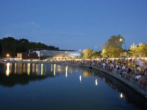 a crowd of people sitting around a river at night at Un Petit Coin de Provence - Istres - Maison Contemporaine Avec Piscine Privée Chauffée, Entre Plages Et Provence, Borne 11 kW in Istres