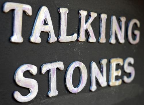 a close up of a metal sign that says eating stones at Talking Stones in Dolceacqua