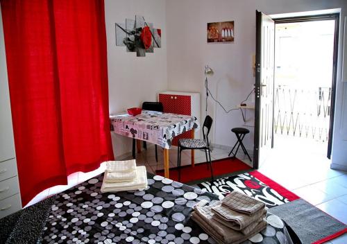 ミラノにあるBnButler - Col di Lana - Navigli Apartment - Darsenaのテーブルと赤いカーテン付きの部屋