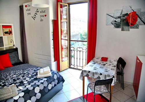 ミラノにあるBnButler - Col di Lana - Navigli Apartment - Darsenaのベッドルーム1室(ベッド1台、テーブル、窓付)