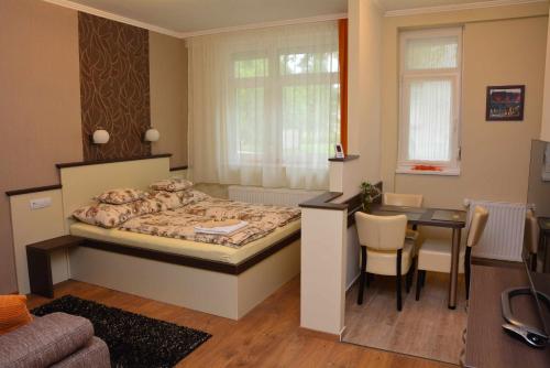 a small bedroom with a bed and a table at Bodza Apartmanok in Eger