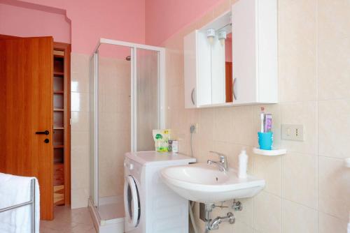 a bathroom with a sink and a washing machine at Residence Kimba in Rimini