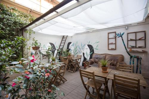 un patio con mesas, sillas y plantas en Tomato Urban Retreat, en Turín