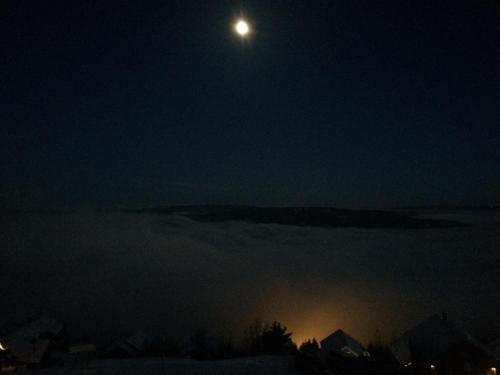 a full moon rising over the fog at night at Norefjell Panorama in Noresund