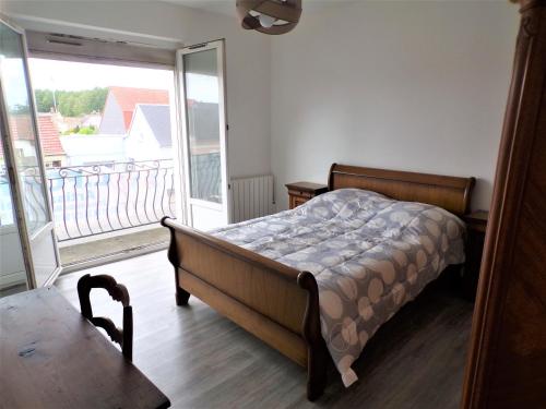a bedroom with a bed and a balcony at Roseau in Berck-sur-Mer