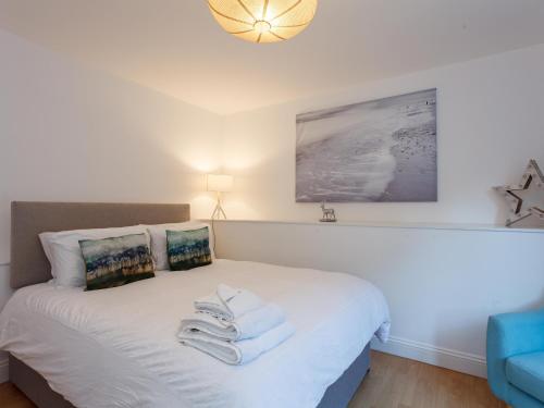 1 dormitorio con 1 cama con toallas en Dale House - Vivre Retreats, en Bournemouth