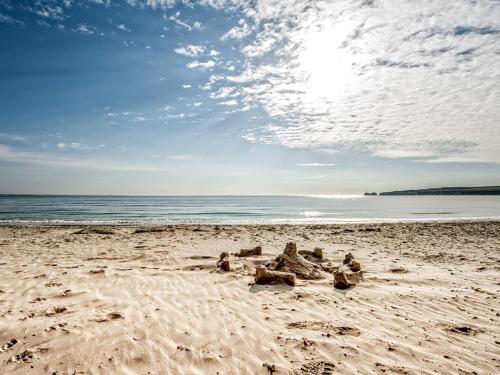 a group of people laying in the sand on a beach at Dale House - Vivre Retreats in Bournemouth