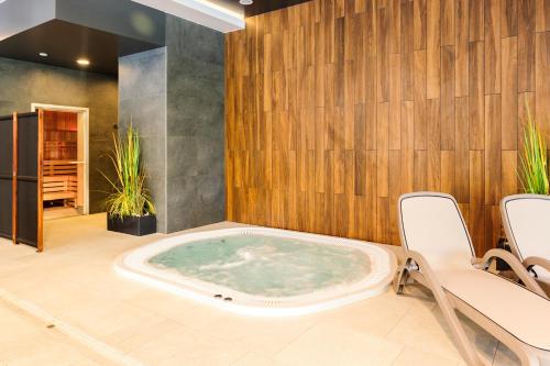 jacuzzi w pokoju z dwoma krzesłami w obiekcie Green Point Apartment Kołobrzeg w Kołobrzegu